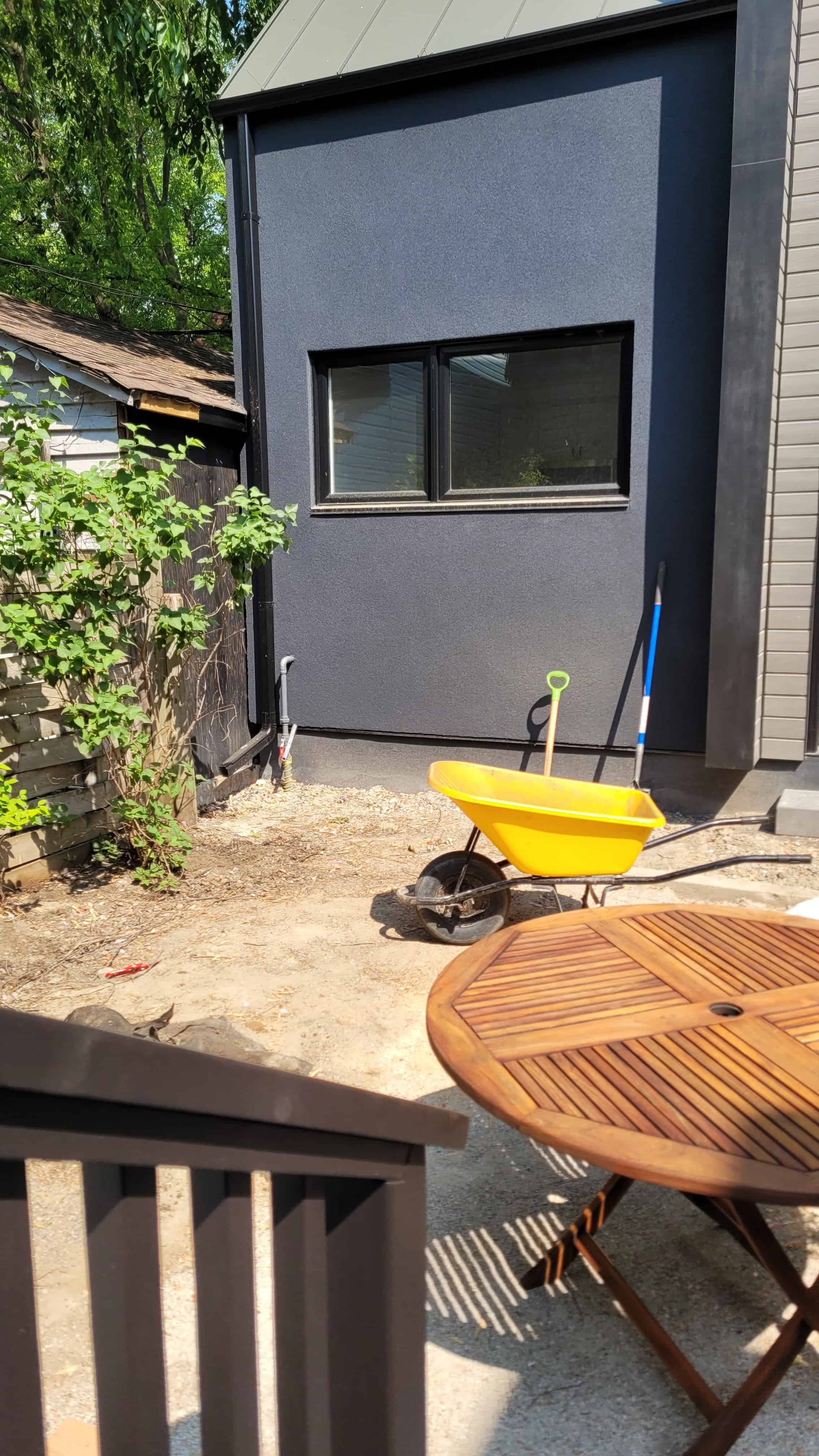 Wooden table and chairs in backyard under construction.